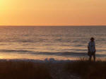 Mother enjoys morning sunrise strolls along the shore.