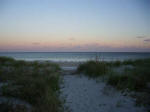 Walking on the beach path toward the surf at dawn.