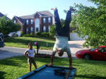 Katrina watches Tim do a handstand on the pooltable.