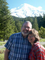 Joe and Ruth against a backdrop of Mount Rainier with the glitter of sun on snow in the morning, & home that night. Seatac International Airport lies about 65 miles north of the Park; driving back from our airport takes 15 minutes or so.